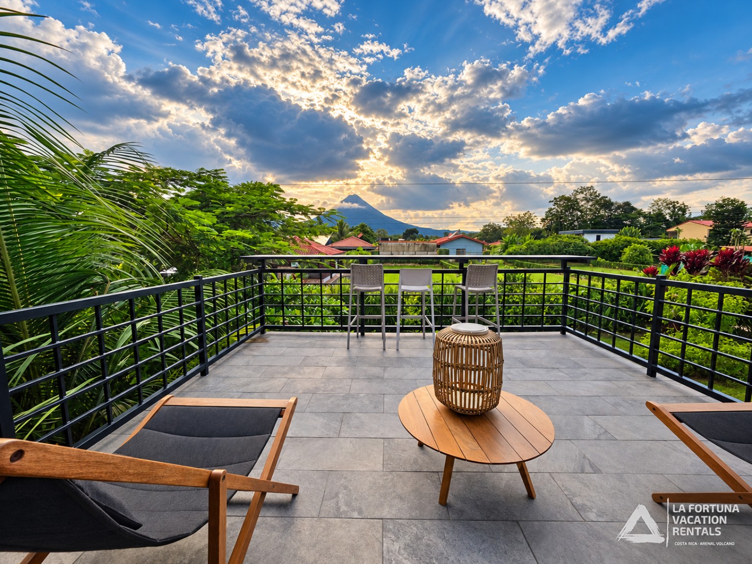 Rooftop terrace with tropical gardens and Arenal Volcano at sunset in La Fortuna, Costa Rica